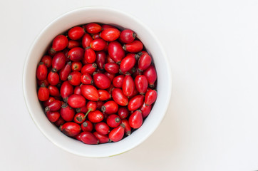 Closeup of rose-hip berries in white bow with white background