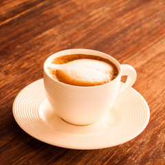 A cup of hot latte  coffee  on a wooden table.