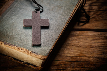 Closeup of wooden Christian cross on bible