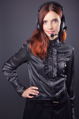 beautiful business woman with headphones against dark grey backg