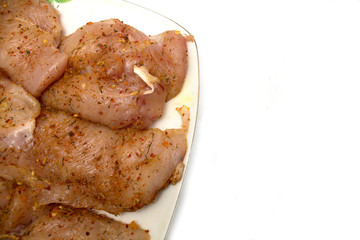 Fillet of fresh raw chicken with seasoning on a plate. Photo.