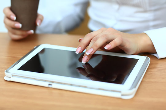 Close up hands woman using tablet in cafe