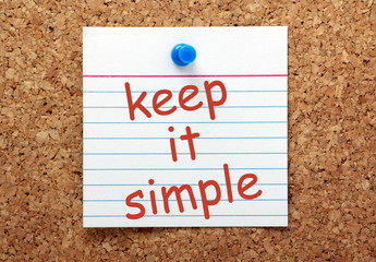 Keep It Simple reminder note on a cork notice board