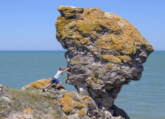 Man pushing a large rock into the abyss