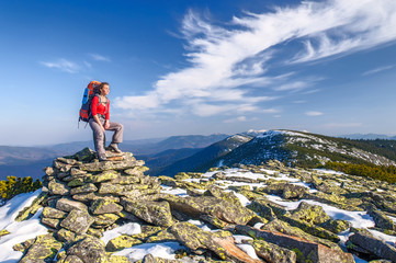 Hiker girl with backpack  in a mountains