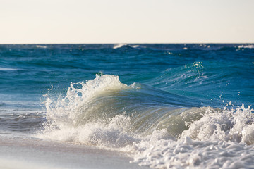 Waves on the beach of a tropical sea on sunset