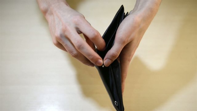 hands turn inside an empty wallet