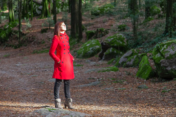 Woman enjoying the warmth of the winter sunlight on a forest