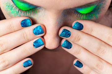 Woman's lips with beautiful multicolor Minx nails and make-up