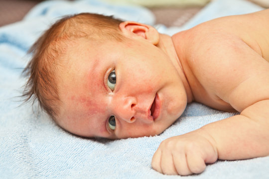 newborn boy lying on the towel and looking at the camera
