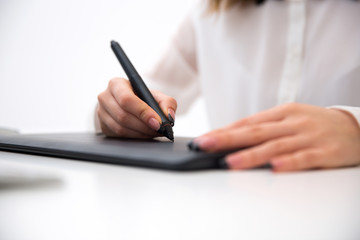 Closeup image  of female hands working on graphic tablet