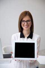 Smiling businesswoman showing tablet computer screen