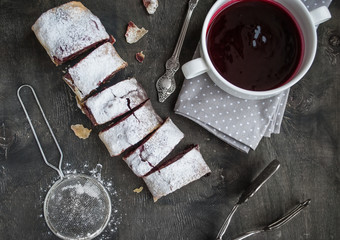 Cherry and walnut strudel on a dark wooden  table. Selective foc