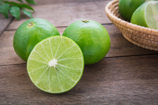 Fresh lime with slices on wooden table