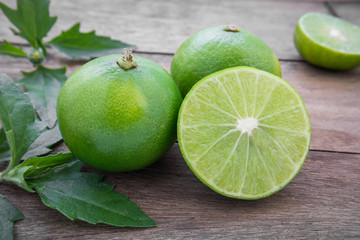 Fresh lime with slices on wooden table