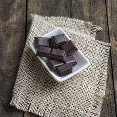 Broken chocolate bar on wooden table