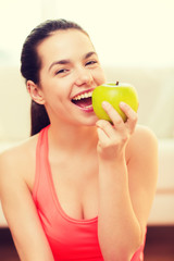 smiling teenage girl with green apple at home