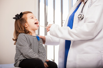 Little girl opening mouth for doctor