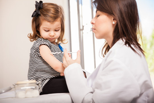 Pediatrician giving a girl a shot