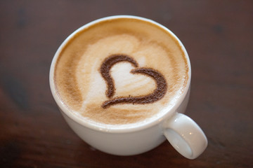 Coffee cup with milk and heart shape