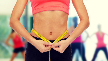 close up of female hands measuring waist