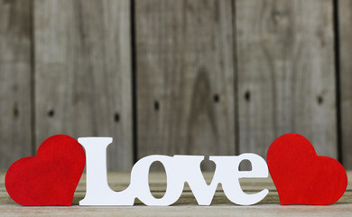 Wood Love text with red hearts by wooden background