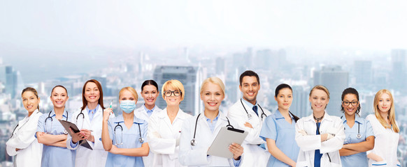 smiling female doctors and nurses with tablet pc
