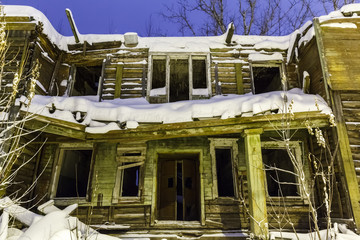 old wooden ruined barracks at winter night