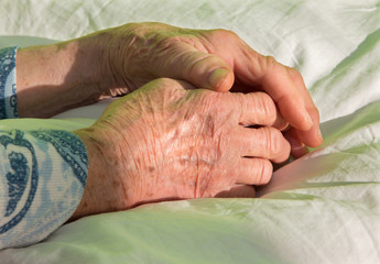 hands of old woman on the bed