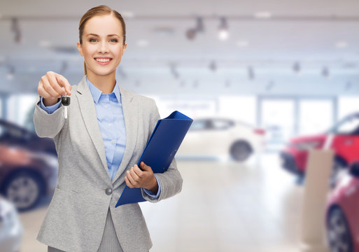 businesswoman or saleswoman giving car key