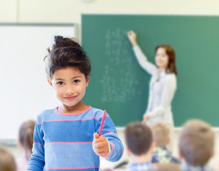 happy little school girl over classroom background