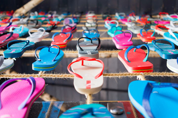 many flip flop sandals aligned on a string