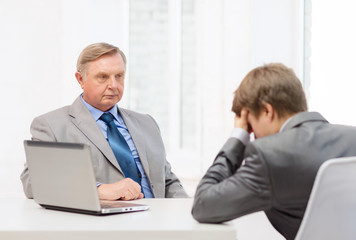 older man and young man having argument in office
