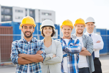 group of smiling builders in hardhats outdoors