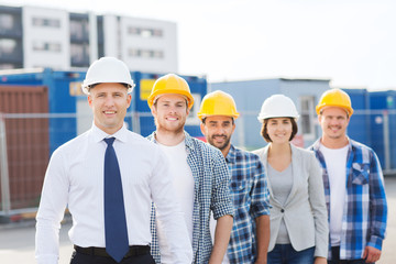 group of smiling builders in hardhats outdoors