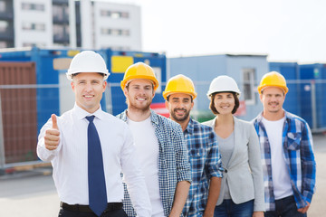 group of smiling builders in hardhats outdoors