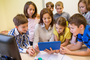 group of kids with teacher and tablet pc at school