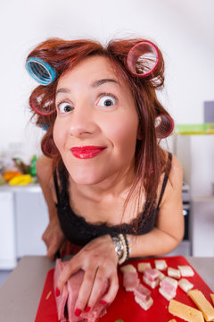 Young pretty woman housewife cooking with curlers hair