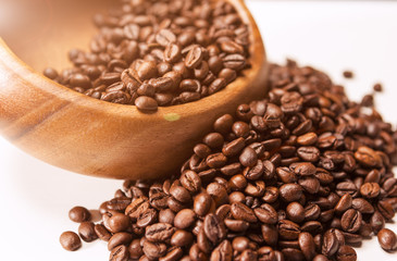 Closeup of Wooden Bowl with Heap of Arabica Coffee Beans on Whi