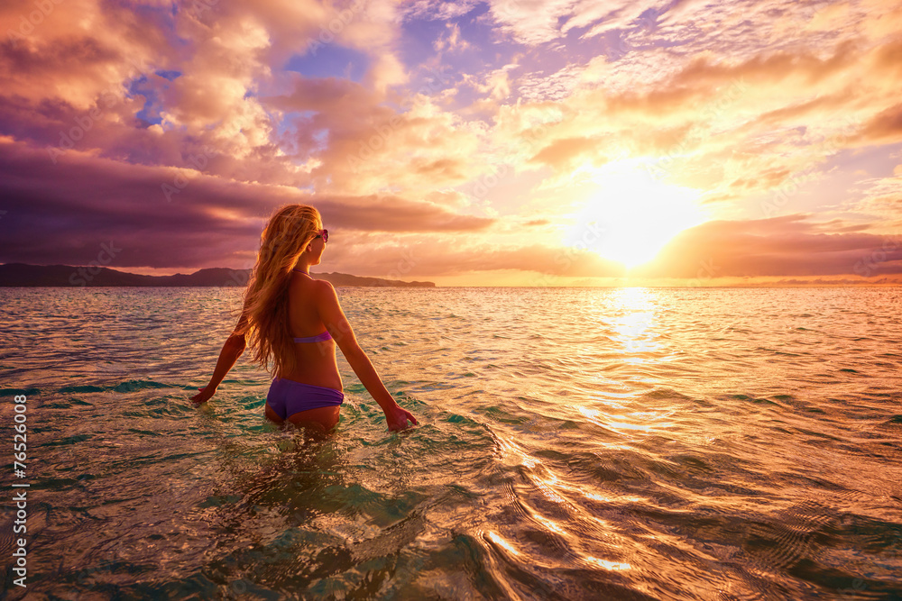 Wall mural carefree woman in the sunset on the beach. vacation vitality hea