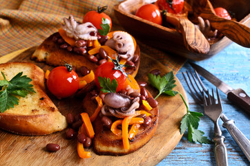 Bruschetta with salad vegetables and octopus