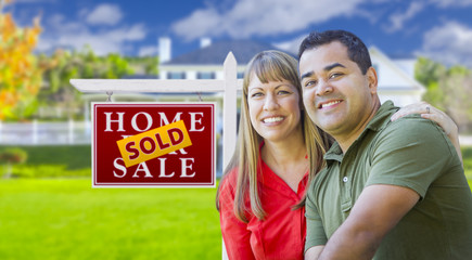 Couple in Front of Sold Real Estate Sign and House