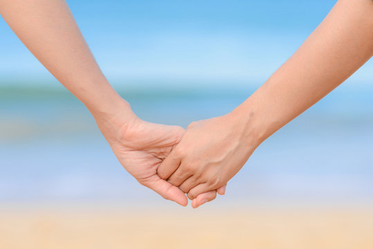 friend holding hand together and the sea background