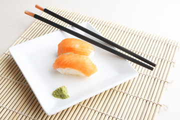 Plate of salmon sushi on bamboo mat