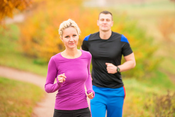 woman and man in autumn park on morning jog
