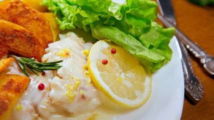 Lemon baked Haddock with fried Potatoes. Lemon sause,