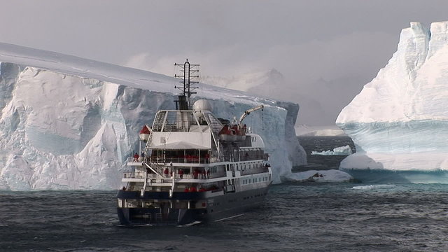 Cruise ship in front of icebergs in Antarctica