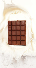 Dark chocolate splashed into fresh milk with white background.