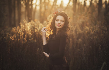 Fototapeta premium Portrait of a cute brunette autumn sunset