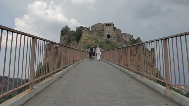tourists walking on a uphill road  to reach a medieval village - steep - hill